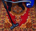 Man cleans an old carpet with an electric vacuum cleaner Royalty Free Stock Photo