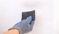 A man cleans old paint on wooden door with sandpaper. Smoothing out irregularities. Royalty Free Stock Photo