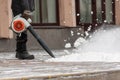 Man cleans street from snow with blower