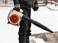 Man cleans street from snow with blower