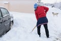 Man cleans road after a big snowstorm. Man digging snow with shovel near car after a big snowstorm.. Royalty Free Stock Photo