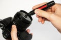 A man cleans a SLR camera with a brush