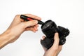 A man cleans a SLR camera with a brush