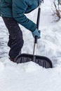 A man cleans the snow near the house with a big black shovel. Royalty Free Stock Photo