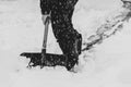 A man cleans the snow path in winter with a shovel in a snowfall Royalty Free Stock Photo