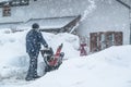 A man cleans snow from sidewalks with snowblower in Bavaria Germany