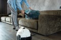 A man cleans the sofa and furniture with a steam generator. Cleaning service of the apartment. flat la. Strong vapor pressure. Royalty Free Stock Photo