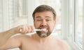 Man cleans teeth electric toothbrush