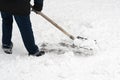 A man clearing away the freshly fallen snow with trusty iron shovel, complete with a wooden handle Royalty Free Stock Photo