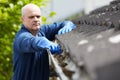 Man Clearing Leaves From Guttering Of House Royalty Free Stock Photo