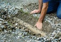 Man clears drainage ditch in driveway Royalty Free Stock Photo