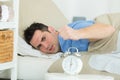 man clenching fist towards alarm clock Royalty Free Stock Photo