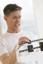 Man Clenching Teeth While Using Balance Weight Scale