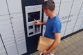 Client using automated self service post terminal machine or locker to deposit a parcel for storage