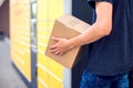 Man client using automated self service post terminal machine or locker to deposit the parcel for storage