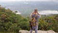 Man solo traveler and adventurer professional landscape photographer on a cliff photographing the valley and jungle