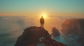 Man on cliff at sunset, admiring ocean view and colorful sky Royalty Free Stock Photo