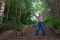 the man climbed the stairs to the very top. A man on an abandoned stone staircase in the forest