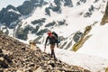 Man climber with ice axe with a large backpack standing on mountain Royalty Free Stock Photo
