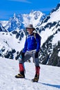 Man climber standing and smiling on mountain top. Royalty Free Stock Photo