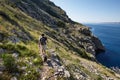 Man climbing cliifs with his dog along the sea