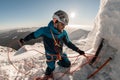 man with climbing equipment fixes rope on mountain slope against the backdrop of landscape and sky