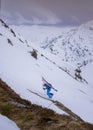 Man climbing mountain on ski tour with skis on back, Zillertal Austria