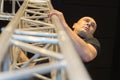 Man climbing on stairway metal tower