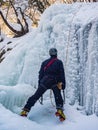 The man climbing up the frozen waterfall