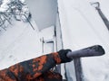 A man climbs a ladder onto a winter roof