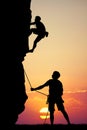 Man climbs mountain at sunset