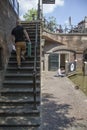 Man climbs stone stairs at canal oudegracht in medieval city of utrecht while other man rests in the sun