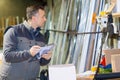 man with clipboard in factory preparaing parcel for despatch