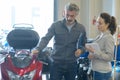 Man with clipboard looking at motorcycle Royalty Free Stock Photo