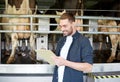 Man with clipboard and milking cows on dairy farm Royalty Free Stock Photo