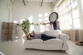 Man-clock waking the girl who lies on the couch in the loft.