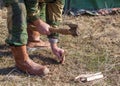 A man clogs a peg at a campsite