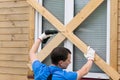 A man clogs the window with boards before a natural disaster