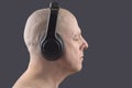 Man with closed eyes listens to music with headphones on dark background Royalty Free Stock Photo