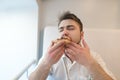 Man closed his eyes from swaddling while eating a tasty pizza. A man eats with his hands a piece of appetizing pizza