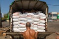 A man closes the back door of a truck, filled to the top with sacks of rice Royalty Free Stock Photo