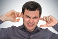 Man closes ears with fingers to protect from loud noise Royalty Free Stock Photo