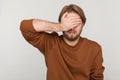 Man closes eyes with hand, dont want to see that, ignoring problems, hides from stressful situations Royalty Free Stock Photo