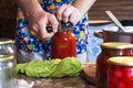 The man closes with jars of pickled tomatoes and a sauce of flour in a rustic kitchen Royalty Free Stock Photo