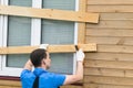 Man closes the window boards before the hurricane Royalty Free Stock Photo