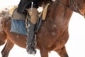 A man in clothes for riding a horse in a winter forest. Close-up of the rider`s foot in stirrups Royalty Free Stock Photo