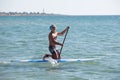 Man in clown mask paddleboarding Royalty Free Stock Photo