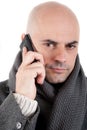 Man with coat and scarf on the phone.