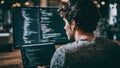 Man coding on computer with multiple screens in a dimly lit environment Royalty Free Stock Photo