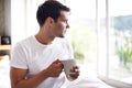 Man, coffee and bed with window for morning, wakeup, daydream or thinking with sunlight and caffeine. Young and male Royalty Free Stock Photo
